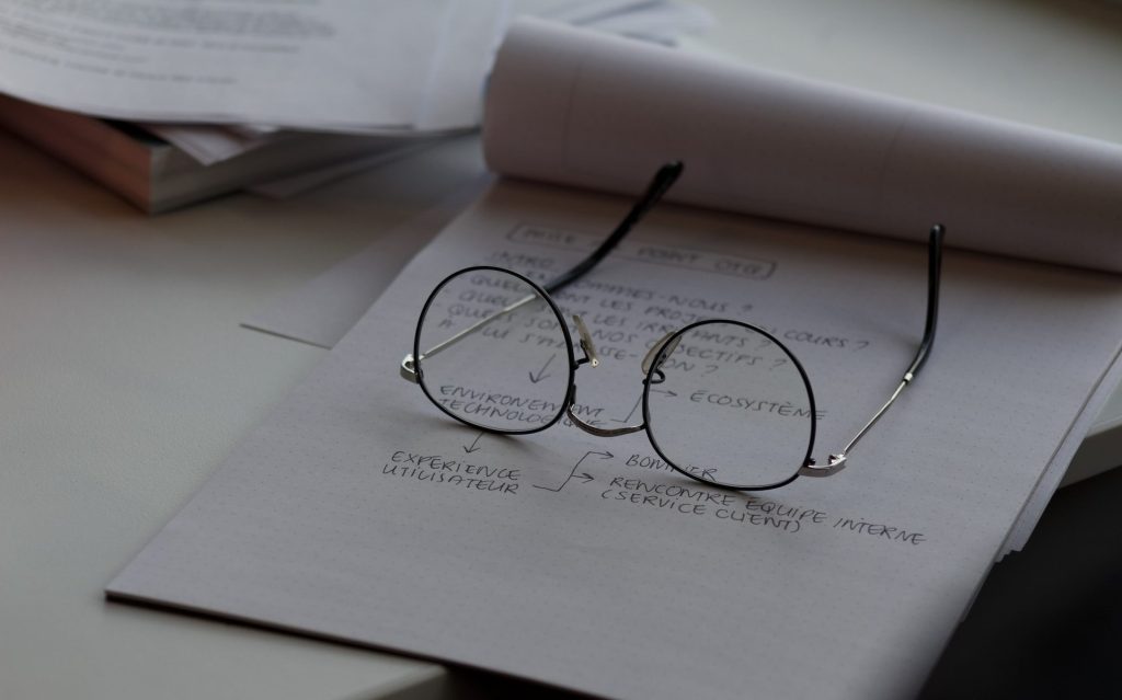 black framed eyeglasses on top of white printing paper